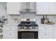 Close-up of modern kitchen showcasing a stainless steel oven, white cabinets, and stylish backsplash at 2009 Friendship Dr, Indianapolis, IN 46217