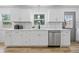 Bright kitchen featuring white cabinetry, stainless steel dishwasher, and light wood flooring at 2009 Friendship Dr, Indianapolis, IN 46217
