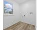 Vacant laundry room featuring white walls, light wood floors, and a window for natural light at 2009 Friendship Dr, Indianapolis, IN 46217