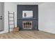 Living room featuring a painted brick fireplace, wooden floors, and a ladder to add character to the room at 2009 Friendship Dr, Indianapolis, IN 46217