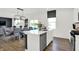 Modern kitchen with an island and seating with an open view into the dining and living area at 2243 Hemlock Cir, Greenfield, IN 46140