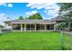 Backyard of home with sunroom addition and manicured lawn at 313 E South St, Morristown, IN 46161