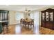 Bright dining room featuring hardwood floors, a ceiling fan, and adjacent kitchen access at 313 E South St, Morristown, IN 46161