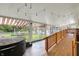 Sunroom with vaulted ceiling, tiled flooring, and access to backyard at 313 E South St, Morristown, IN 46161