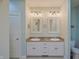 This bathroom is equipped with white cabinets, granite countertops, and framed mirrors at 3247 Moonlight Ct, Columbus, IN 47203