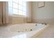 Bright bathroom featuring a luxurious soaking tub next to a window with natural lighting at 3247 Moonlight Ct, Columbus, IN 47203