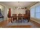 Bright dining room with hardwood floors, modern chandelier, and large windows with shutters at 3247 Moonlight Ct, Columbus, IN 47203