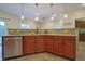 Well-lit kitchen with stainless steel dishwasher and wood cabinets at 3247 Moonlight Ct, Columbus, IN 47203