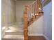 Carpeted staircase with natural wood railing, showcasing transition to another level at 3247 Moonlight Ct, Columbus, IN 47203