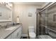 Modern bathroom with white vanity, gray countertop, and walk-in shower with stylish tile work at 35 Osage Ct, Columbus, IN 47201
