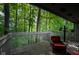 View of the deck surrounded by lush trees and featuring wooden railings and a comfortable chair at 35 Osage Ct, Columbus, IN 47201