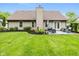 Home's backyard with lush green grass, a small patio set, and a well-maintained lawn at 3630 Foxtail Dr, Indianapolis, IN 46235