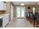 Functional kitchen area with white cabinets, a breakfast bar, and access to the outdoor space at 3630 Foxtail Dr, Indianapolis, IN 46235