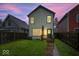 Back exterior of a charming home with a small deck, grassy yard, and secure fencing at 3658 Graceland Ave, Indianapolis, IN 46208