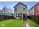 Charming two-story home with a well-maintained back exterior, small deck, and fenced yard at 3658 Graceland Ave, Indianapolis, IN 46208