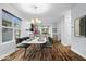 Bright dining area features hardwood floors, a modern table set, and an open layout to the kitchen at 3658 Graceland Ave, Indianapolis, IN 46208
