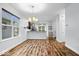 Bright dining area features hardwood floors, modern chandelier, and an open layout to the kitchen at 3658 Graceland Ave, Indianapolis, IN 46208