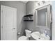 Half bathroom featuring a pedestal sink, toilet, framed mirror, and modern shelving for decor at 3815 Harrison Crossing Ln, Greenwood, IN 46142