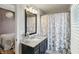 Bathroom with granite countertop, dark vanity, and shower with patterned shower curtain at 3815 Harrison Crossing Ln, Greenwood, IN 46142