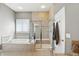 Luxurious bathroom featuring a soaking tub, glass shower, and neutral tiling at 3815 Harrison Crossing Ln, Greenwood, IN 46142