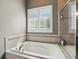 A relaxing bath featuring natural light, neutral tiling, and a glass-enclosed shower at 3815 Harrison Crossing Ln, Greenwood, IN 46142