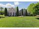 Beautiful brick home with a well-manicured lawn and artfully arranged flower beds and trimmed evergreens at 3815 Harrison Crossing Ln, Greenwood, IN 46142