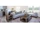 Bright living room with grey couches, wood tables, and lots of natural light at 3899 Sterling Dr, Whitestown, IN 46075