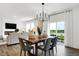 Bright dining area with modern chandelier, wood table, and sliding glass doors to the outdoor space at 3924 Andean Ct, Bargersville, IN 46106