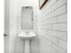 Modern powder room featuring a pedestal sink, white subway tile, and a frameless mirror at 3924 Andean Ct, Bargersville, IN 46106