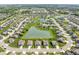 Aerial view of homes in a lovely neighborhood surrounding a pond, with well-manicured lawns at 4659 W Otway Ln, New Palestine, IN 46163