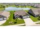 Scenic aerial view of a brick home nestled in a vibrant community with a peaceful pond and lush green spaces at 4659 W Otway Ln, New Palestine, IN 46163