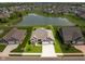 Aerial view of a residence with a pond, showcasing the home's curb appeal and peaceful community setting at 4659 W Otway Ln, New Palestine, IN 46163