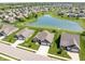 Captivating aerial view showcasing a brick home amidst a serene neighborhood with a tranquil pond and expansive green lawns at 4659 W Otway Ln, New Palestine, IN 46163