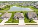 Beautiful aerial view of a brick home in a tranquil community with a scenic pond and well-maintained lawns at 4659 W Otway Ln, New Palestine, IN 46163