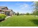 Expansive backyard featuring a manicured lawn, patio, and a tranquil view of the pond and surrounding neighborhood at 4659 W Otway Ln, New Palestine, IN 46163