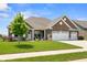 Charming brick home featuring a well-maintained lawn, beautiful landscaping, and a three-car garage at 4659 W Otway Ln, New Palestine, IN 46163