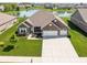 Charming brick home showcasing a well-manicured lawn and a spacious driveway leading to a three-car garage at 4659 W Otway Ln, New Palestine, IN 46163