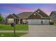 Charming brick home featuring a three-car garage, well-manicured lawn, and inviting curb appeal at 4659 W Otway Ln, New Palestine, IN 46163