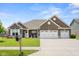 Attractive brick home with a well-kept lawn, front porch seating, and a convenient three-car garage at 4659 W Otway Ln, New Palestine, IN 46163