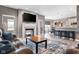 Open-concept living room with a cozy fireplace, a plush leather sofa, and views into the dining area at 4659 W Otway Ln, New Palestine, IN 46163