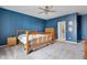 Comfortable main bedroom featuring a blue accent wall and natural wood furniture at 4659 W Otway Ln, New Palestine, IN 46163