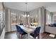 Bright dining room featuring modern chandelier, blue chairs, and patio door access at 5151 Nettleton Way, Avon, IN 46123