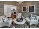 Inviting flex room showcasing a chandelier, comfortable seating, and views into the kitchen at 5151 Nettleton Way, Avon, IN 46123