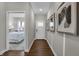 Hallway view with wood floors, art and neutral paint, leading to a bedroom with a large window at 5151 Nettleton Way, Avon, IN 46123