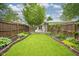 Well-maintained backyard features a green lawn, landscaping, and a wooden fence at 5225 E St Clair St, Indianapolis, IN 46219
