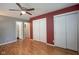 Cozy bedroom featuring hardwood floors, ceiling fan, and closet with sliding doors at 5225 E St Clair St, Indianapolis, IN 46219