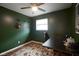 Cozy bedroom with dark-green walls, ceiling fan, area rug, and hardwood floors at 5225 E St Clair St, Indianapolis, IN 46219