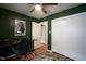 Cozy bedroom with dark-green walls, ceiling fan, closet, and hardwood floors at 5225 E St Clair St, Indianapolis, IN 46219