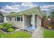 Charming single-story home featuring a well-maintained lawn and a welcoming front entrance with unique architectural details at 5225 E St Clair St, Indianapolis, IN 46219