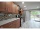 Bright kitchen with granite countertops, stylish cabinets, and stainless steel refrigerator next to the door to the back yard at 5225 E St Clair St, Indianapolis, IN 46219
